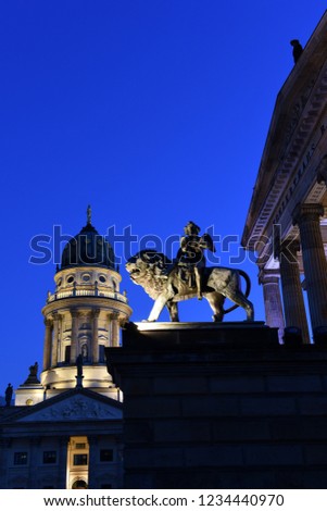 Konzerthaus Berlin with lion statue on Gendarmenmarkt square at night with German cathedral in the background, Berlin City, Germany
