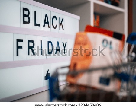 Bright poster with the words Black Friday. Shopping cart filled with coins, bills and a credit card.