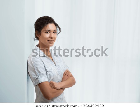 Portrait of a young beautiful woman near the wall