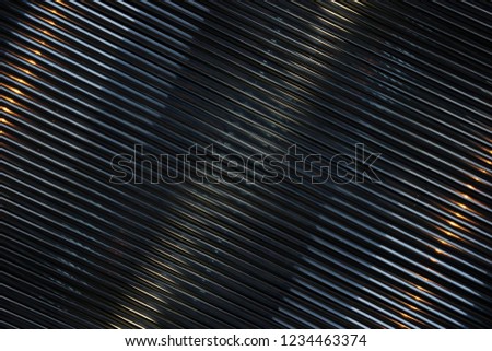 Grid structure. Close-up of modern architecture fragment. Diagonal geometric composition with parallel lines of blinds / louvers / shutters in darkness.
