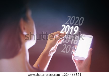 Woman select 2019 on her smartphone. New 2019 year in high tech.
