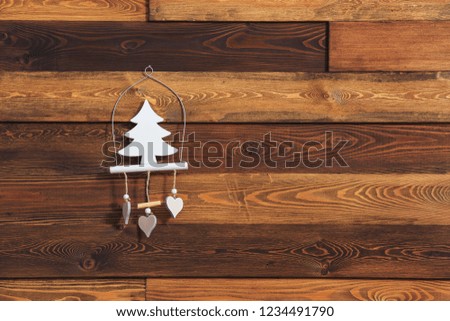 Christmas wooden decoration in the shape of a Christmas tree. Decoration on a wooden wall. White toy in the shape of a Christmas tree. Eco-friendly toy. Christmas decoration