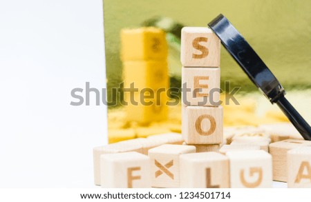SEO word on wooden block with magnifying glass on wooden alphabets abbreviation SEO.Search Engine Optimization ranking concept.