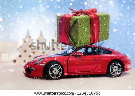 The concept of a Christmas celebration with gift boxes on a red toy car audio.