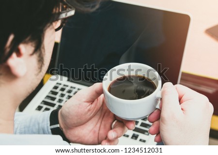 newsletter concept Hand of businessman holding cup of coffee and checking message box on digital laptop in the morning