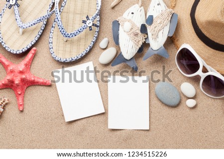 Travel vacation concept with hat, sunglasses, seashells and photo frames on sand backdrop. Top view with copy space. Flat lay