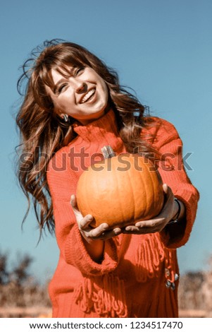Young woman on a pumpkin farm. Beautiful girl near pumpkins. A girl with a pumpkin. Pumpkin Field. Europe farm.