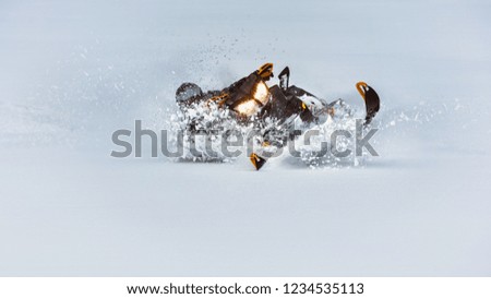 In deep snowdrift snowmobile rider make fast turn. Riding with fun in white snow powder during backcountry tour. Extreme sport adventure, outdoor activity during winter holiday on ski mountain resort.