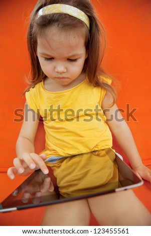 Child holds the plate on an orange background