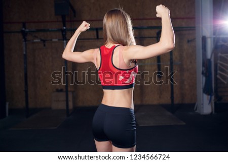 Photo from back of sports woman showing biceps