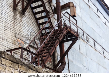 Fully rusty iron staircase in an abandoned old Soviet industrial laboratory. Old rusty iron fire escape at an old abandoned factory since the USSR