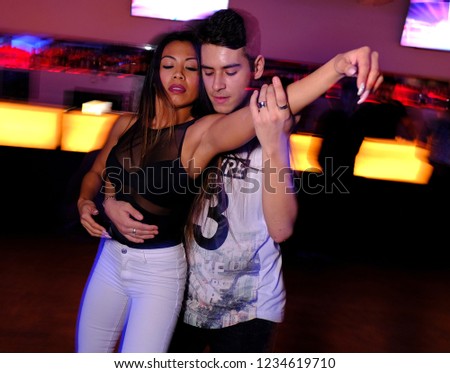 a young couple dancing bachata and salsa at the disco