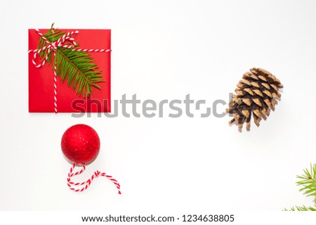 Christmas concept: red envelope decorated with a pine branch, white and red strip and anise star. Copy space. Flatlay.