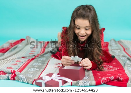 What a great surprise. Kid enjoy Christmas holiday. Cute little child girl with Christmas present. Happy little smiling girl open Christmas gift box. Merry Christmas and Happy Holidays.