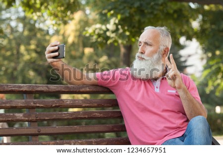 Bearded Senior Man Taking a Selfie at Park