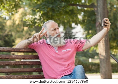 Bearded Senior Man Taking a Selfie at Park