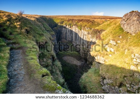 Hull Pot lies on the western side of Pen-y-ghent just to the north of the main footpath, the Pennine Way, which leads from the summit into Horton-in-Ribblesdale. . Royalty-Free Stock Photo #1234688362