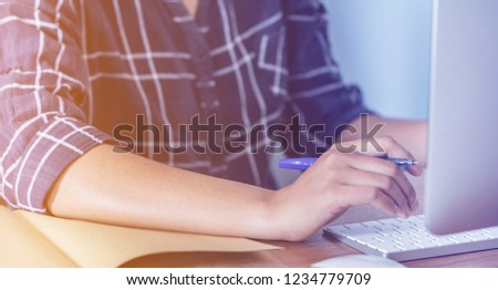 Lady working at home with computer,Her hand holding pen writing a blog and Creative idea of work 2019 goals, writing, drawing, making notes in document Business,investment,concept,Soft focus.