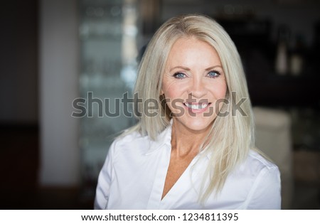 Mature Woman Smiling At Home Royalty-Free Stock Photo #1234811395