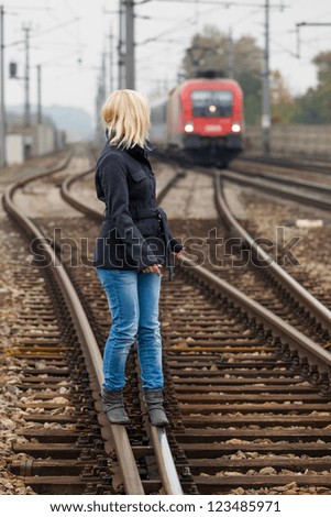in search of the right decision, a young woman balancing on one track. life sets the course.
