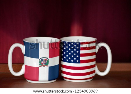 USA and Dominican Republic flag on two cups with blurry background