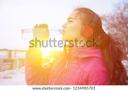 Drinking during sport. Young woman drinking water after run Royalty-Free Stock Photo #1234985701