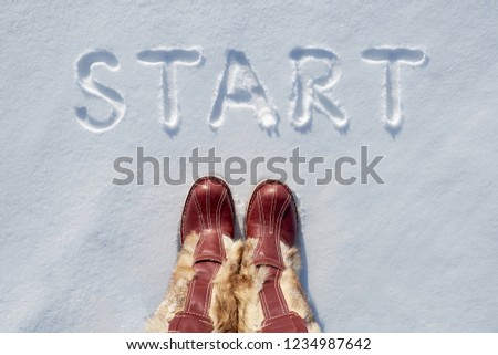 Concept picture.inscription start and national fur boots in the snow