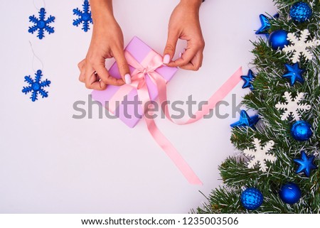 Woman's hands hold christmas or new year decorated gift box. Toned picture
