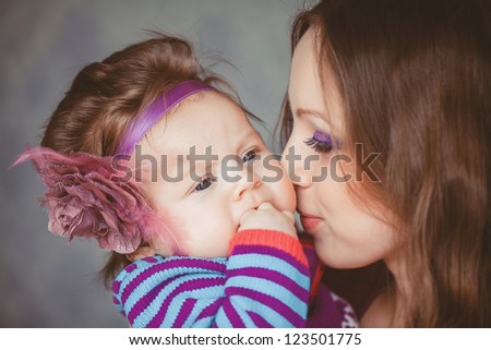 Mother playing with cute baby girl indoor