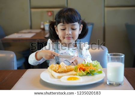 Asian kid having a healthy breakfast in the morning. Royalty-Free Stock Photo #1235020183