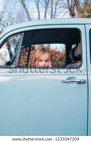 Little blonde girl in the car window