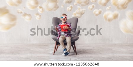 Happy boy in 3d glasses with popcorn in cinema