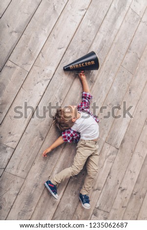 Little boy with a megaphone on the wooden floor
