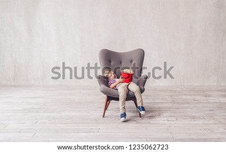 Smiling child with popcorn in a chair