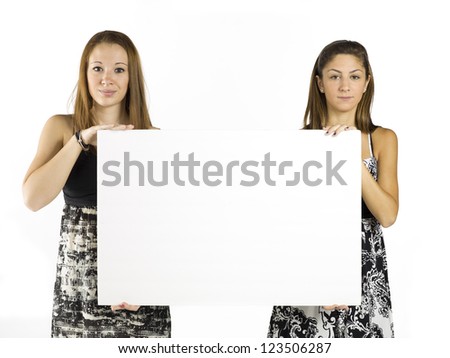 Two teen girls hold up a blank sign