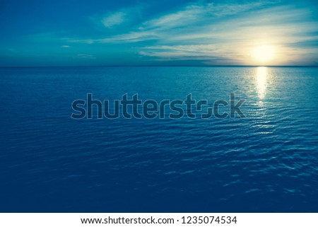Beautiful sunset on seaside at exotic travel destination on ocean shore.Sparkling water surface under dusk lighting in summer evening.