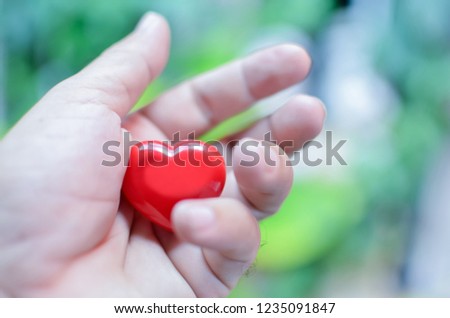 Red heart in hand to replace the love in the Valentine Give heart or love and concern to each other With a natural background.