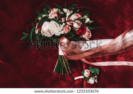 Beautiful wedding bouquet and boutonniere on red velvet top view