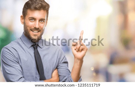Young handsome business man over isolated background with a big smile on face, pointing with hand and finger to the side looking at the camera.