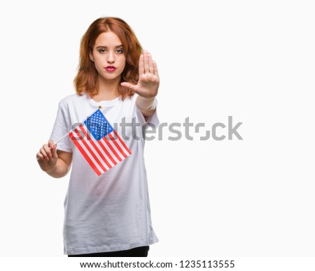 Young beautiful woman holding flag of america over isolated background with open hand doing stop sign with serious and confident expression, defense gesture