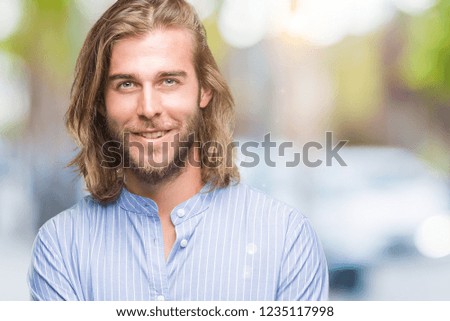 Young handsome man with long hair over isolated background happy face smiling with crossed arms looking at the camera. Positive person.