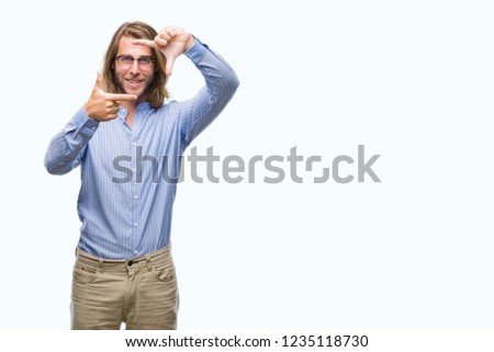 Young handsome man with long hair wearing glasses over isolated background smiling making frame with hands and fingers with happy face. Creativity and photography concept.