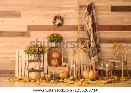 Beautiful autumn composition with pumpkins and leaves near wooden wall