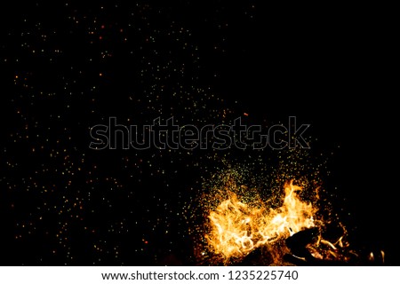 Burning woods with firesparks, flame and smoke. Strange weird odd elemental fiery figures on black background. Coal and ash. Abstract shapes at night. Bonfire outdoor on nature. Strenght of element