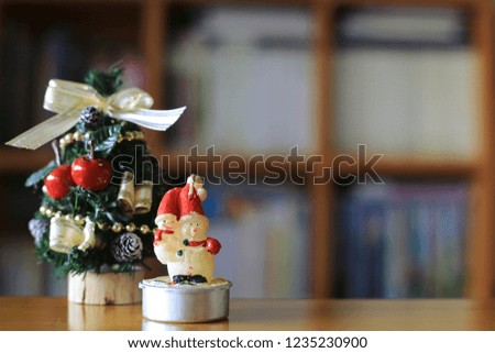 Little snowman on the table in the living room. Christmas tree is the background selective focus and shallow depth of field