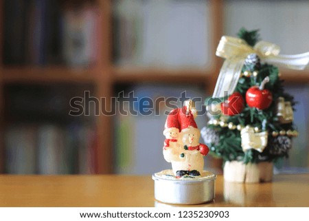 Little snowman on the table in the living room. Christmas tree is the background selective focus and shallow depth of field