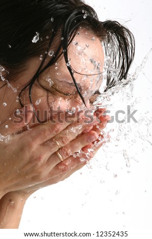 Beautiful woman washing her face (on white background) Royalty-Free Stock Photo #12352435