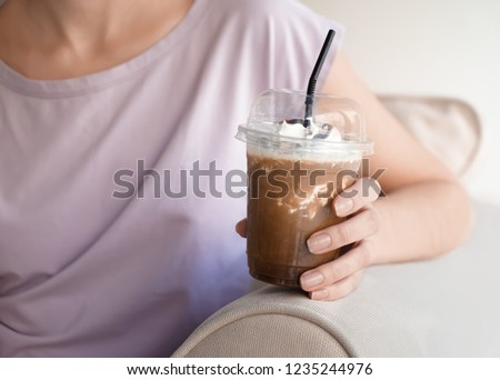 Woman drinking tasty cold coffee, closeup