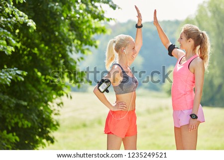 Two woman giving High Five in the air to each other as sign of success and motivation