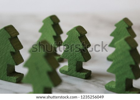 small wooden green Christmas trees close-up on a snowy background
